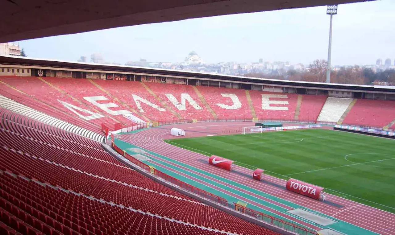 Puste trybuny stadionu Crvena Zvezda czekają na kibiców. Na tle miasta widać charakterystyczną kopułę.