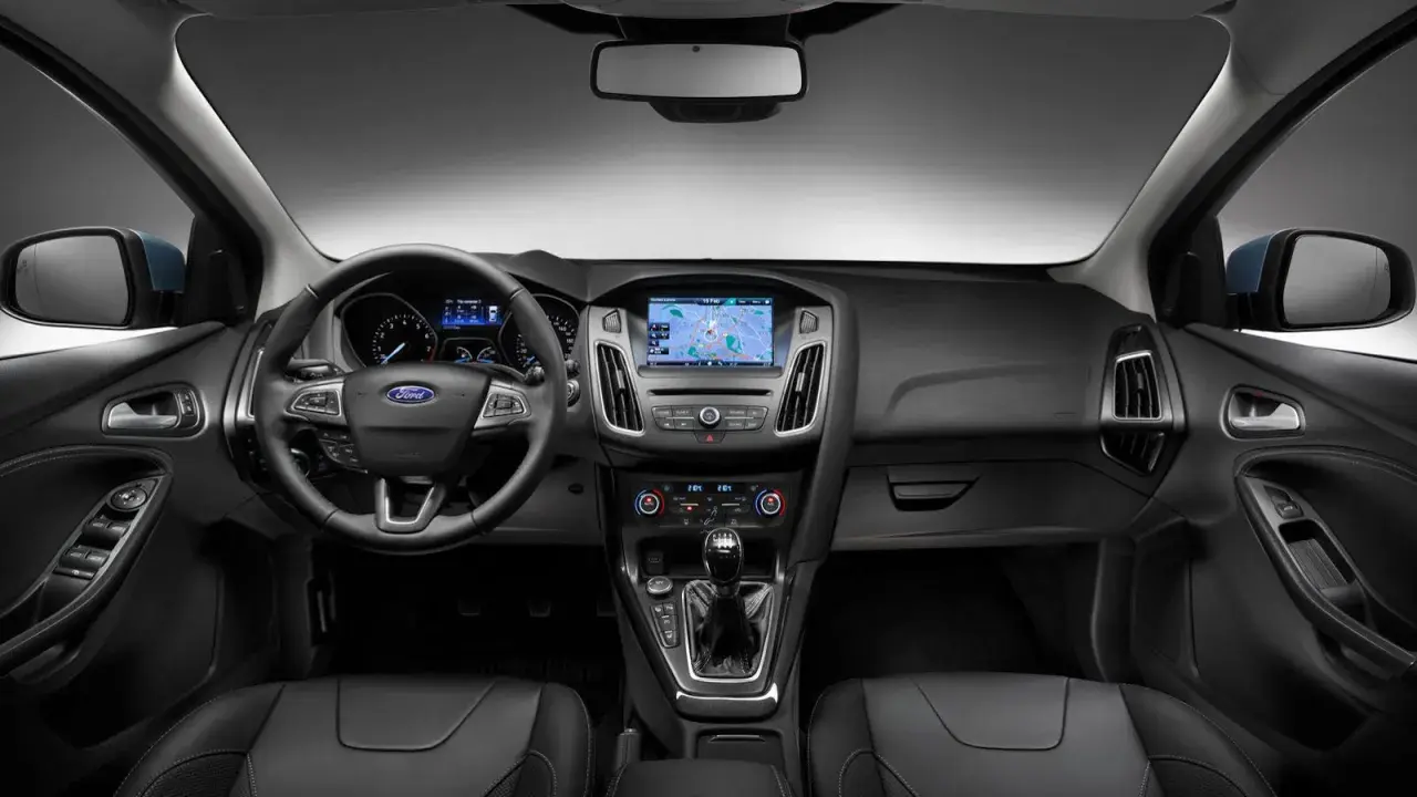 Interiör i en Ford Focus MK2 med ratt, instrumentpanel och mittkonsol. Navigationssystemet visar en karta.