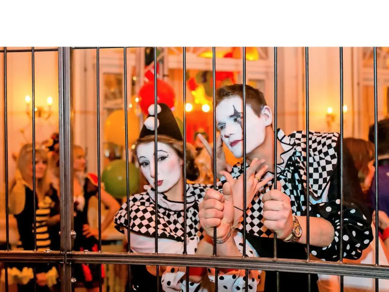 Zwei Clowns hinter Gittern, bereit für den Dresden Karneval. Bunte Ballons und Lichter im Hintergrund.