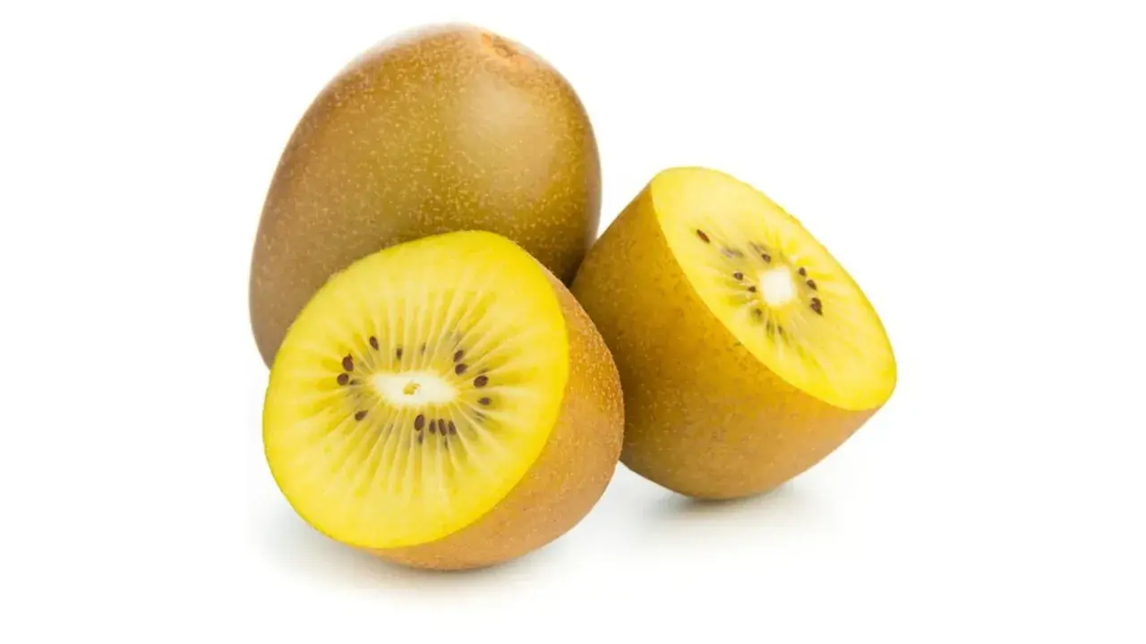 Kiwi amarillo entero y cortado por la mitad, mostrando su pulpa dorada y semillas negras. Descubre sus increíbles kiwi amarillo propiedades.