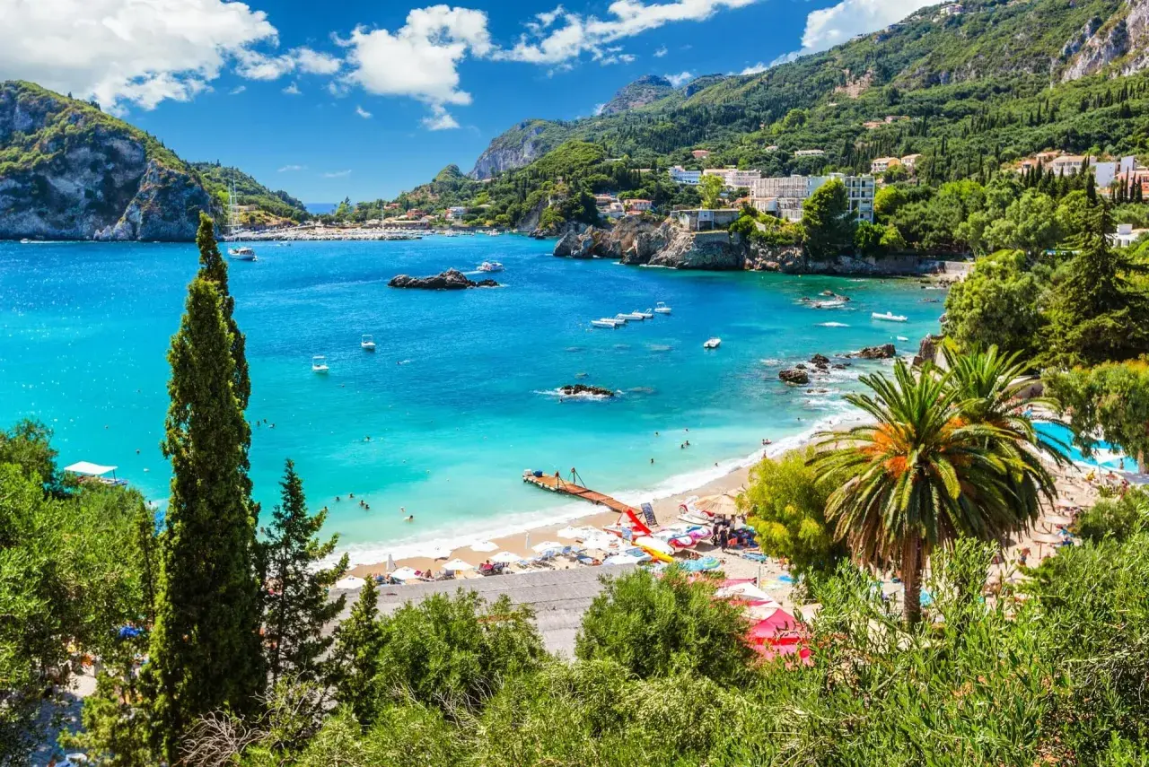 Traumhafte Bucht mit türkisfarbenem Wasser, Palmen und einem Steg. Perfekt für Korfu Reisetipps und einen entspannten Urlaub.