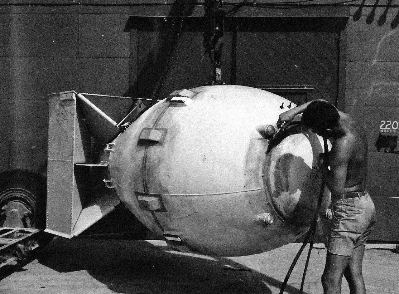 En man arbetar på en stor bomb, kanske för ett film om atombomben. Den hänger i en kran.
