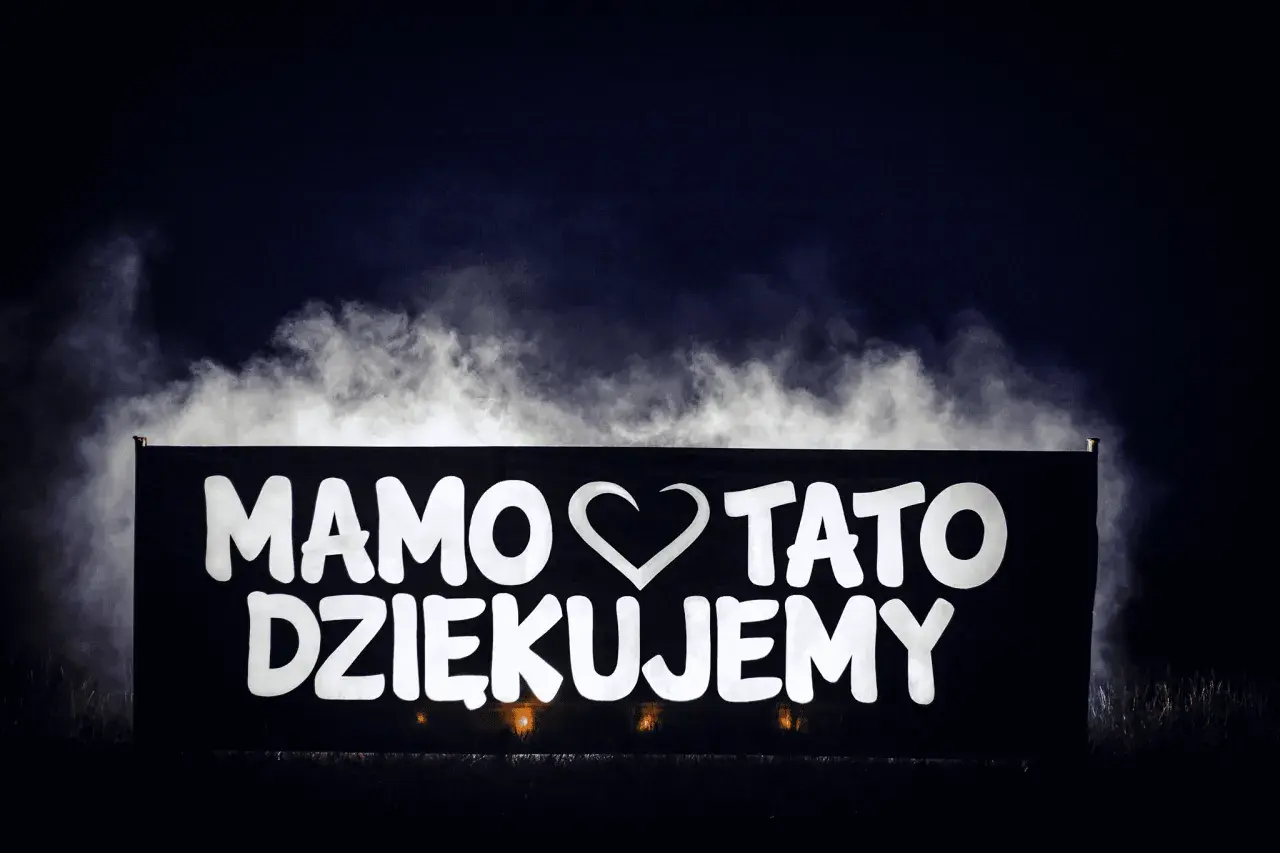 Napis "Mamo, tato, dziękujemy" na banerze, otoczony mgłą. Wspaniałe podziękowania dla rodziców pomysły na wyjątkowy gest.