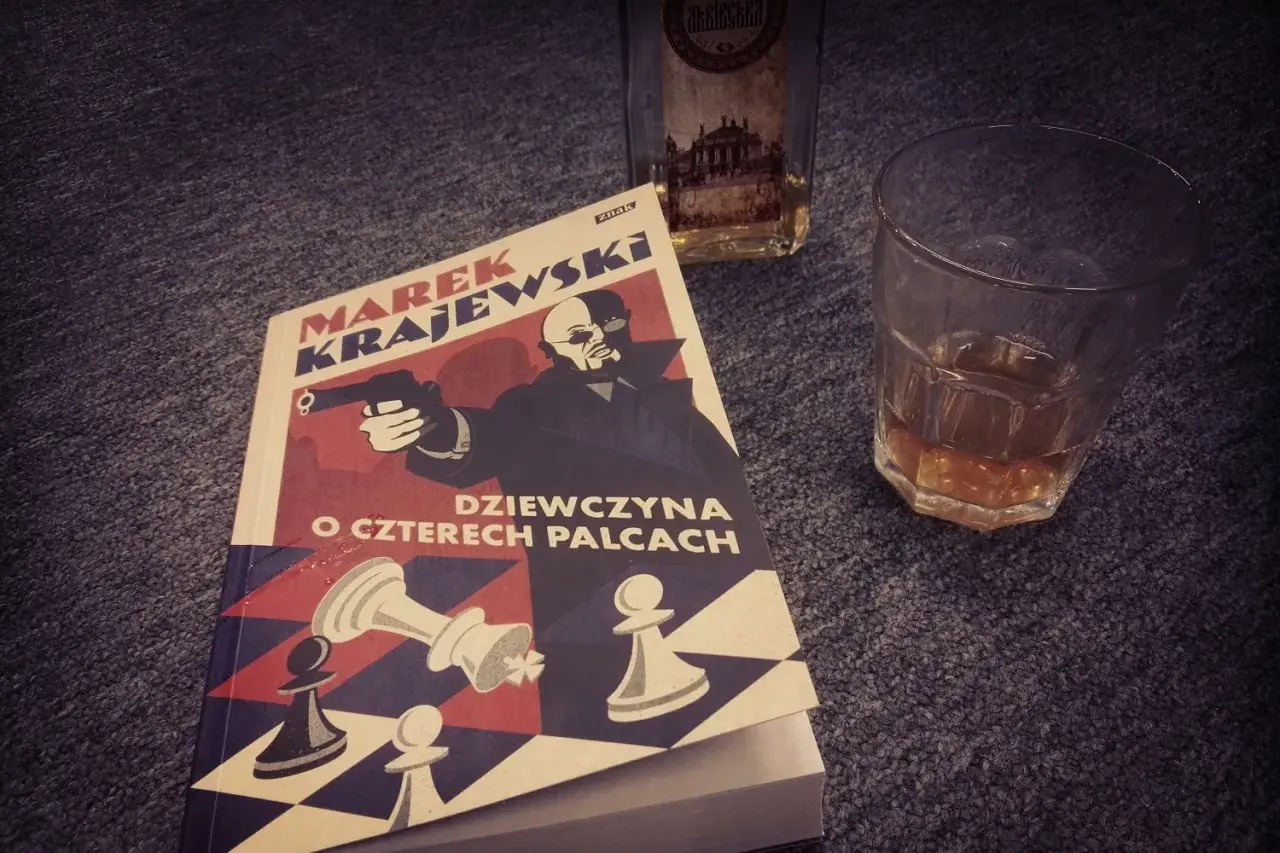 Książka "Dziewczyna o czterech palcach" Marka Krajewskiego, idealna na wieczór z whisky. Kolejność czytania jego powieści jest ważna dla pełnego odbioru.