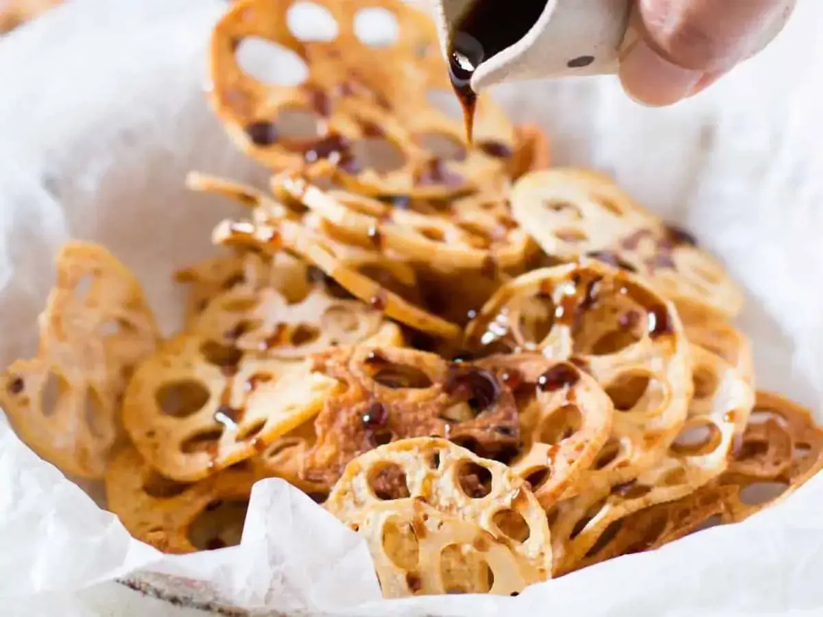 Crispy lotus root chips drizzled with a dark sauce, a simple and delicious addition to your easy Japanese recipes.
