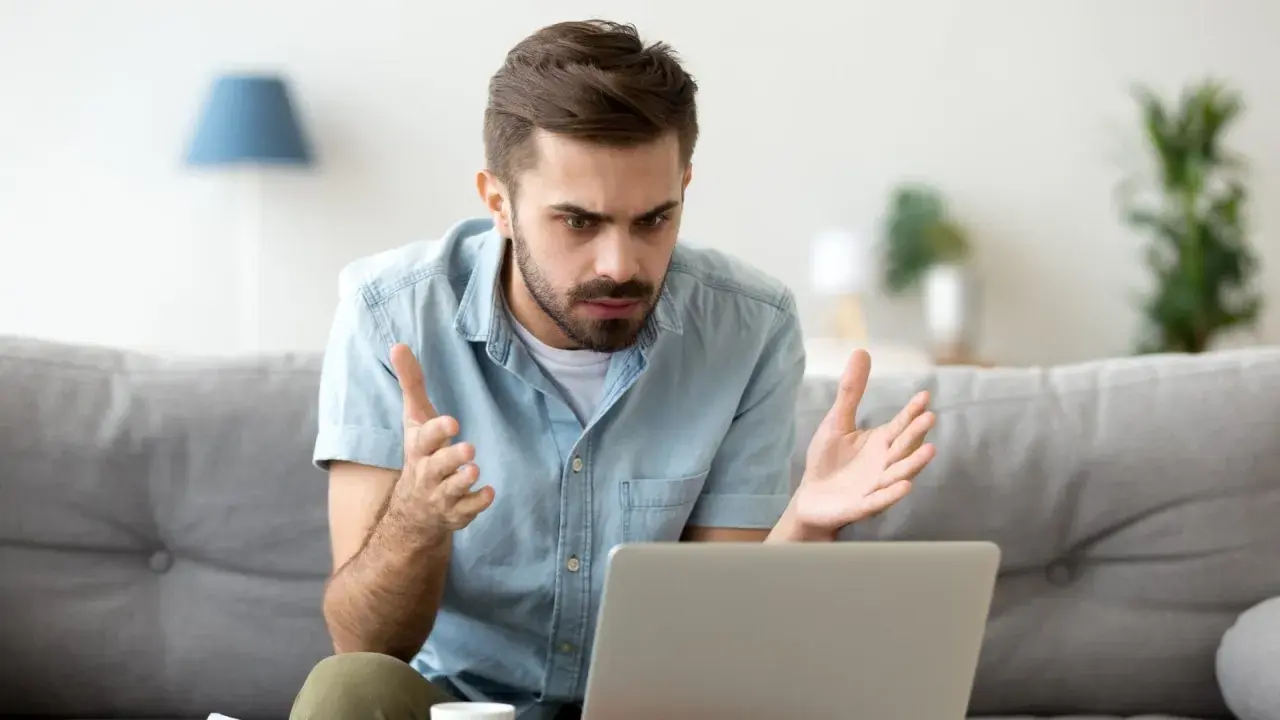 Homme perplexe devant son ordinateur, découvrant une augmentation Deezer inattendue.