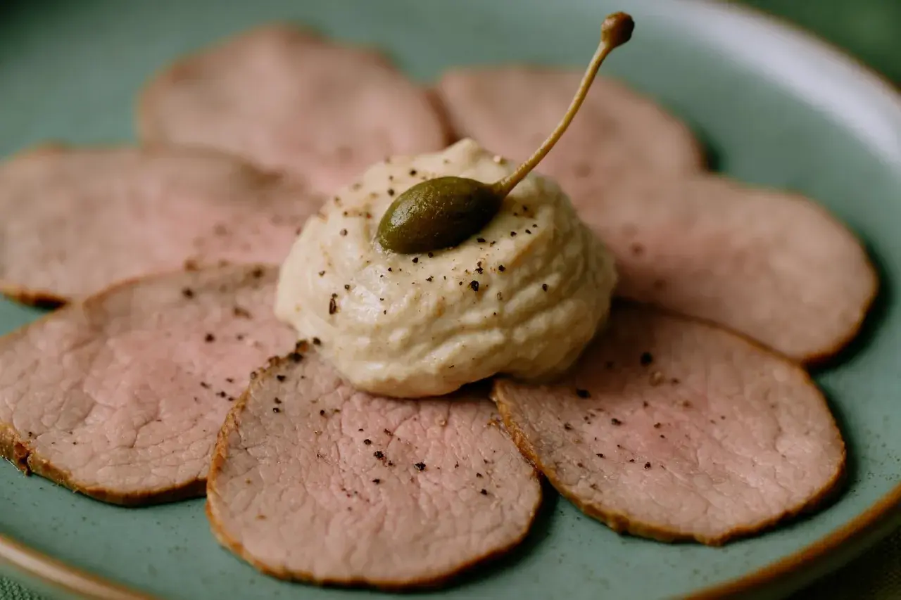 Dünne Scheiben Kalbfleisch, garniert mit einer cremigen Sauce und Kapern. Ein klassisches Vitello Tonnato Rezept, das Appetit macht.