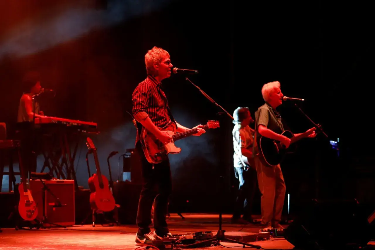 Kiko Veneno y Martirio en concierto, con luces rojas y humo. Kiko toca la guitarra eléctrica, Martirio la acústica.