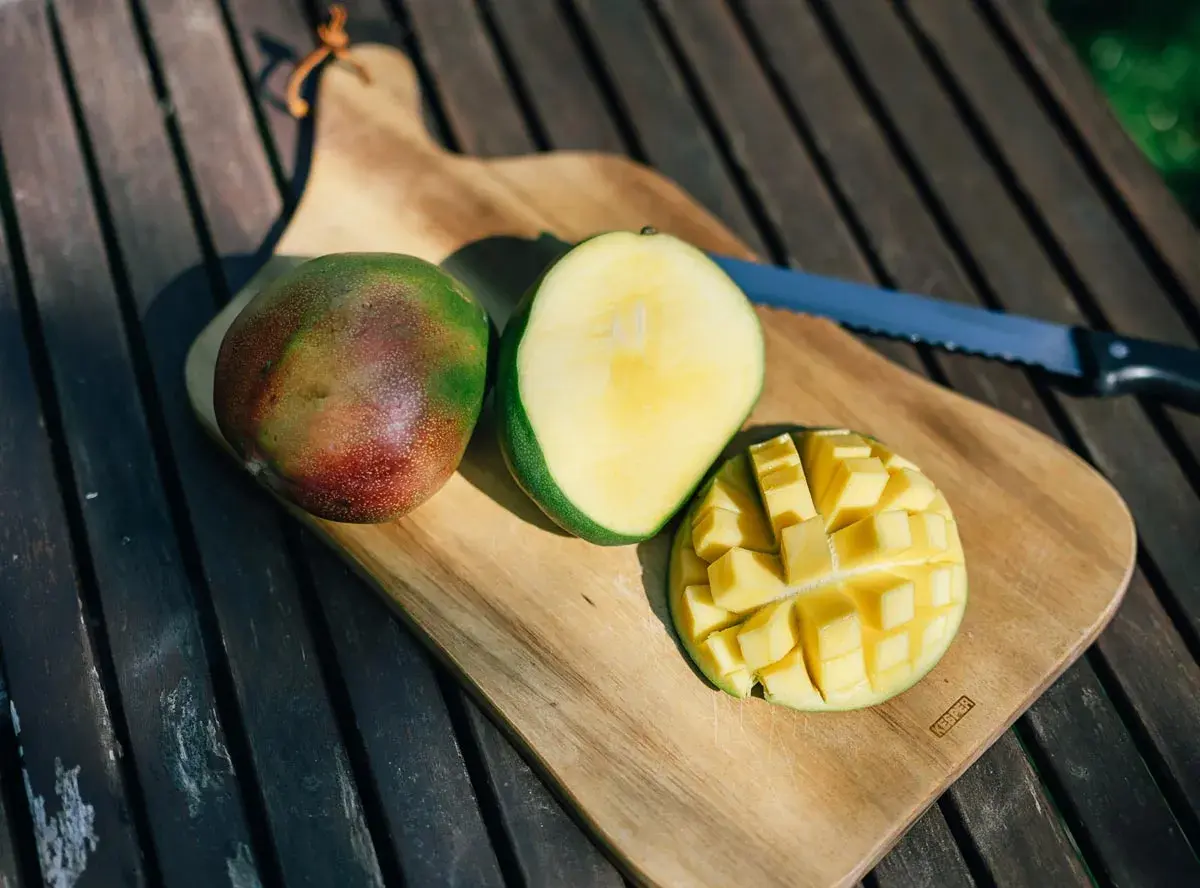 Süße, saftige Mangostücke auf einem Holztisch. Die Frage "ist mango gesund" wird durch diese leckere Frucht beantwortet.