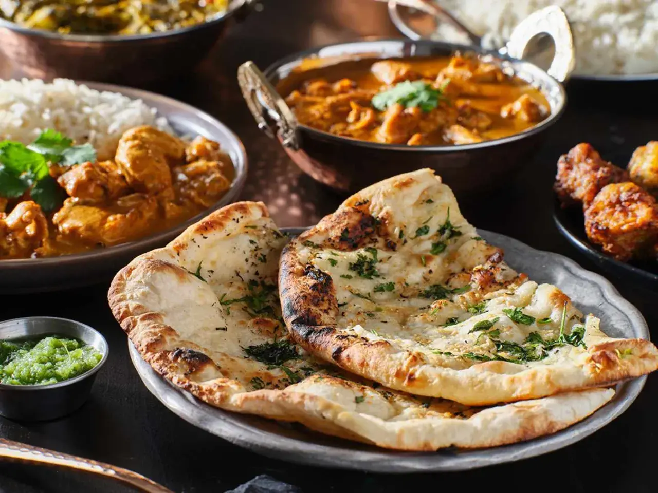 En härlig måltid med indisk mat, inklusive naanbröd, ris och curry. Perfekt för en kväll med vin till indisk mat.