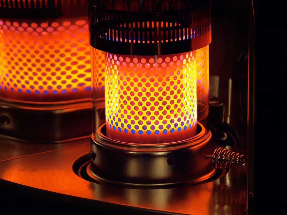 Estufa de parafina encendida, con llama naranja y azul. Considera sus pros y contras para calentar tu hogar.