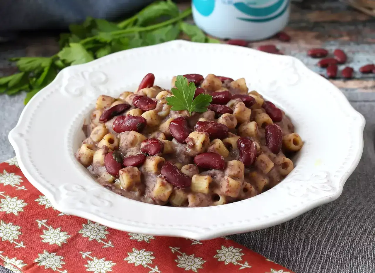 En skål med krämig pasta fagioli, toppad med färska bönor och persilja. Ett härligt recept för en mysig middag.