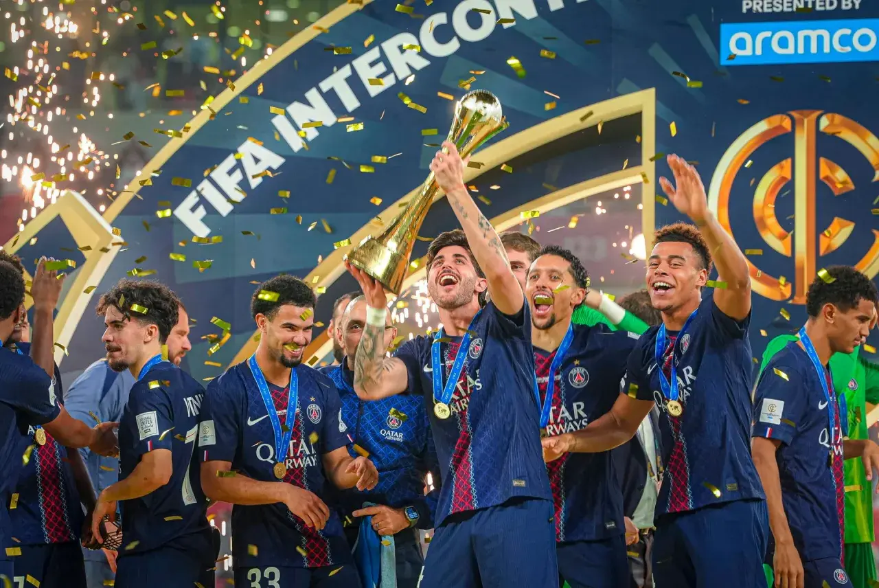 Piłkarze PSG świętują z pucharem, sypie się złoty konfetti. To ich aktualny skład, pełen radości po zwycięstwie.