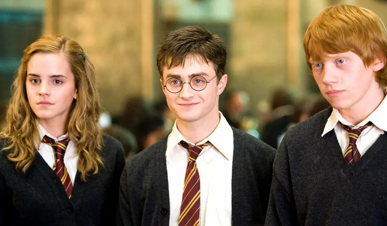 Harry Potter, w okularach, z przyjaciółmi Hermioną i Ronem, wygląda na nastolatka. Ile lat ma Harry Potter? To pytanie nurtuje fanów!