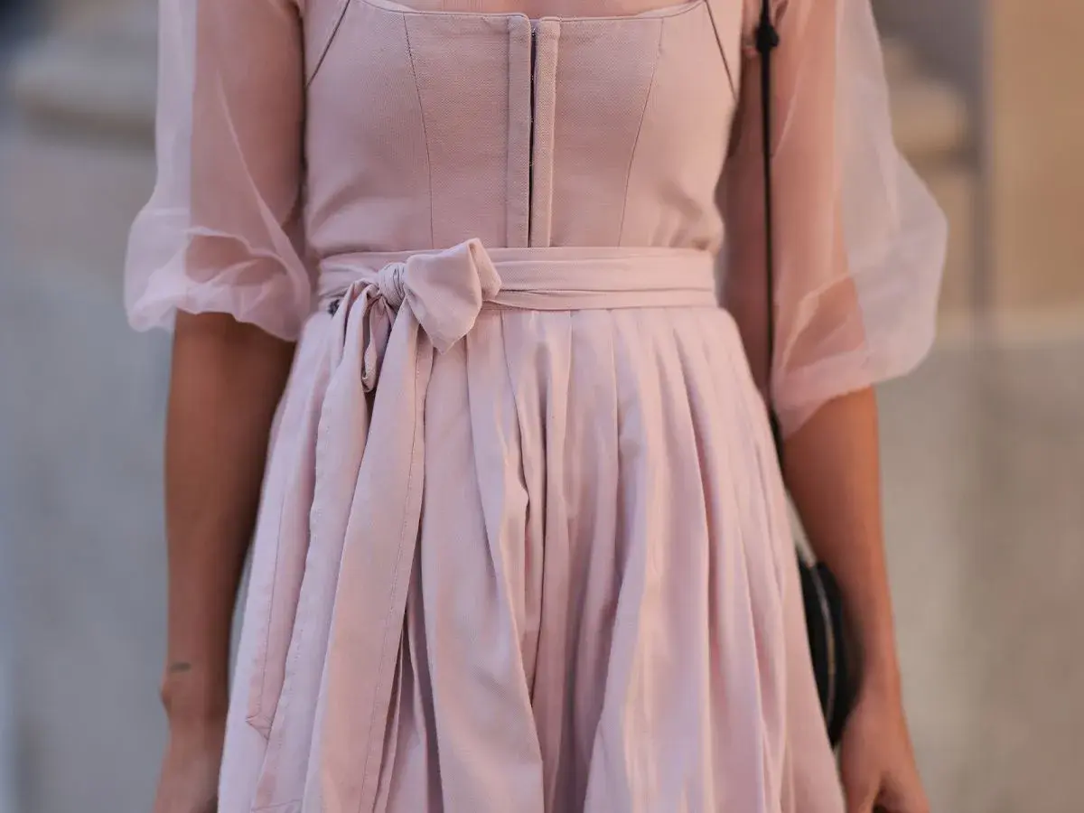 Ein zartrosa Dirndl ohne Schürze mit Puffärmeln aus Tüll. Die Taille ist mit einer Schleife gebunden.