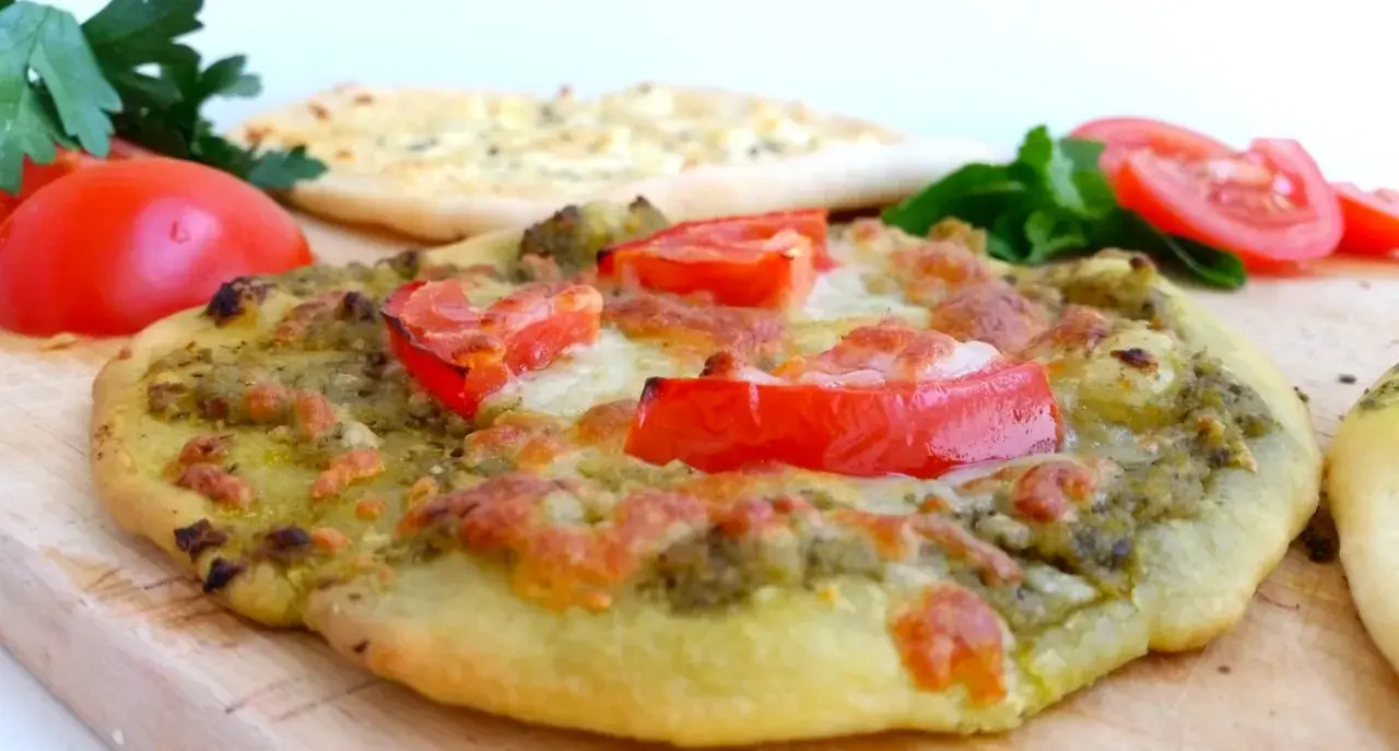En läcker manakish ost med pesto och tomater, redo att avnjutas.