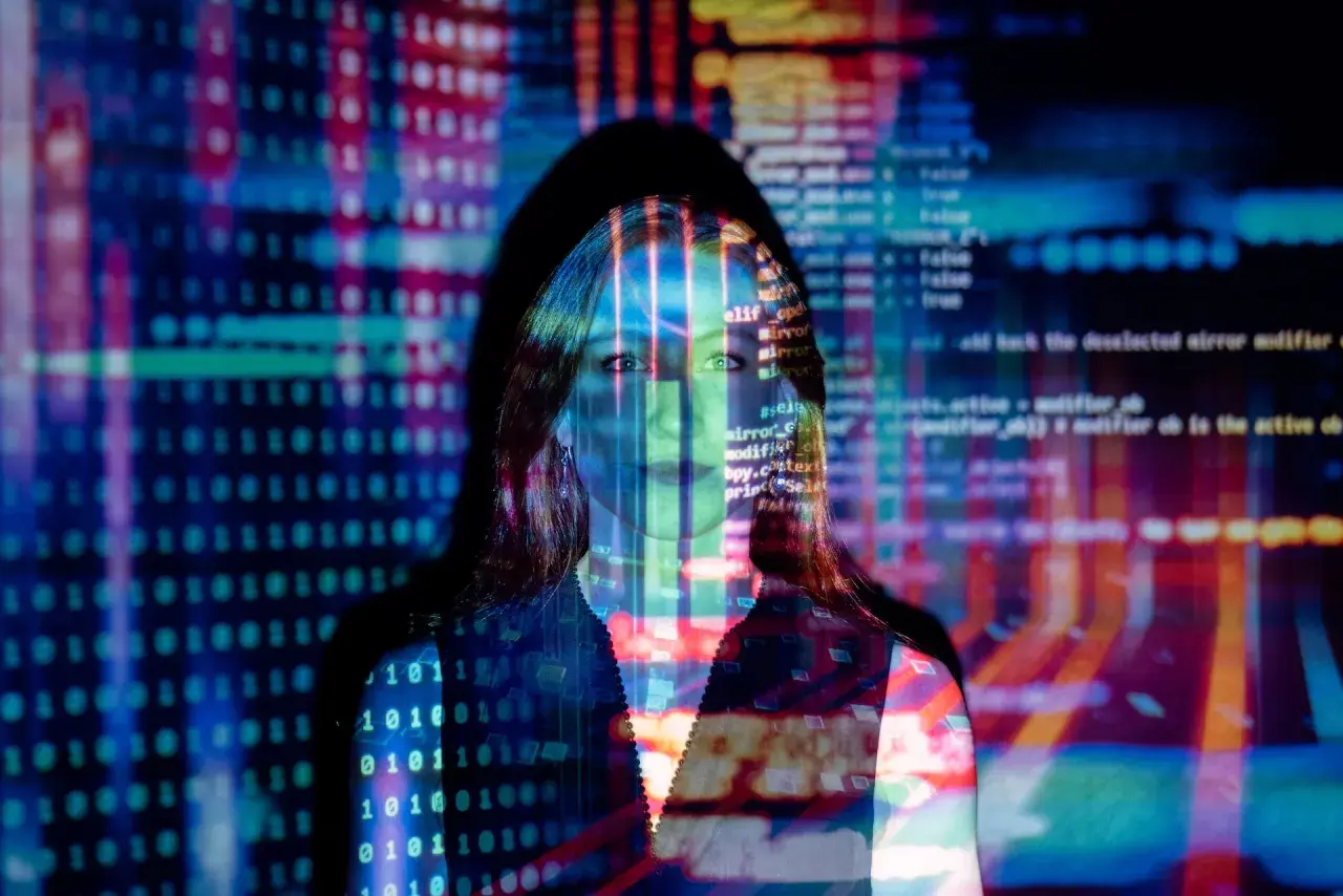 Frau im Fokus, umgeben von leuchtendem Code und Binärcode. Sie repräsentiert die Zukunft des Fernstudium KI.