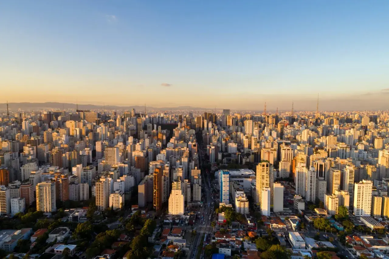 Blick über die riesige Stadtlandschaft von São Paulo bei Sonnenuntergang. Die Frage, wie viel Einwohner hat São Paulo, wird durch diese schier endlose Häusermeer beantwortet.