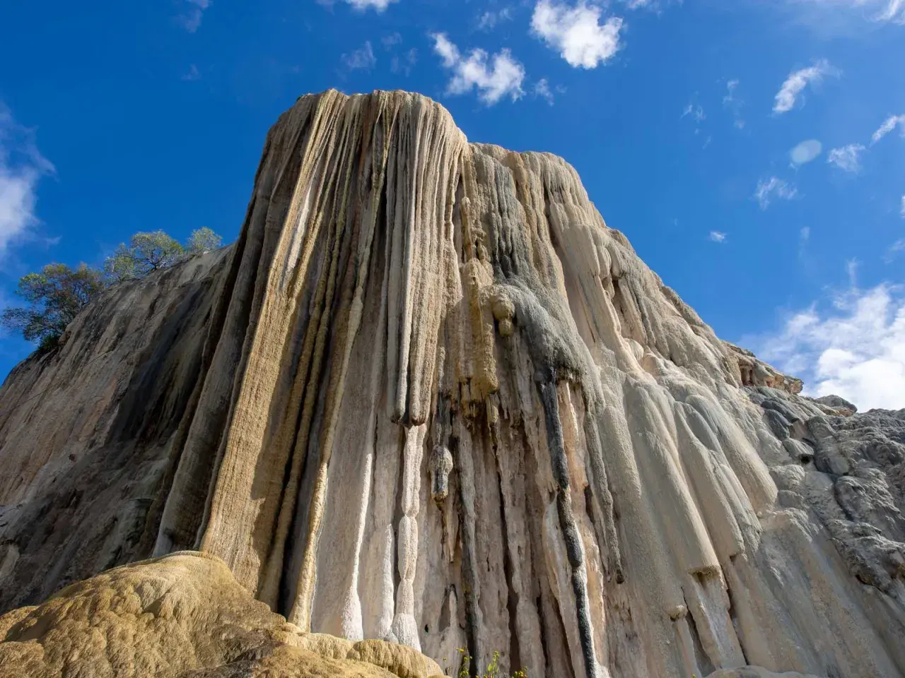 Felsformation, die aussieht, als ob hierve el agua (Wasser kocht) und über die Jahrtausende erstarrt ist. Tropfsteine bilden vertikale Säulen.