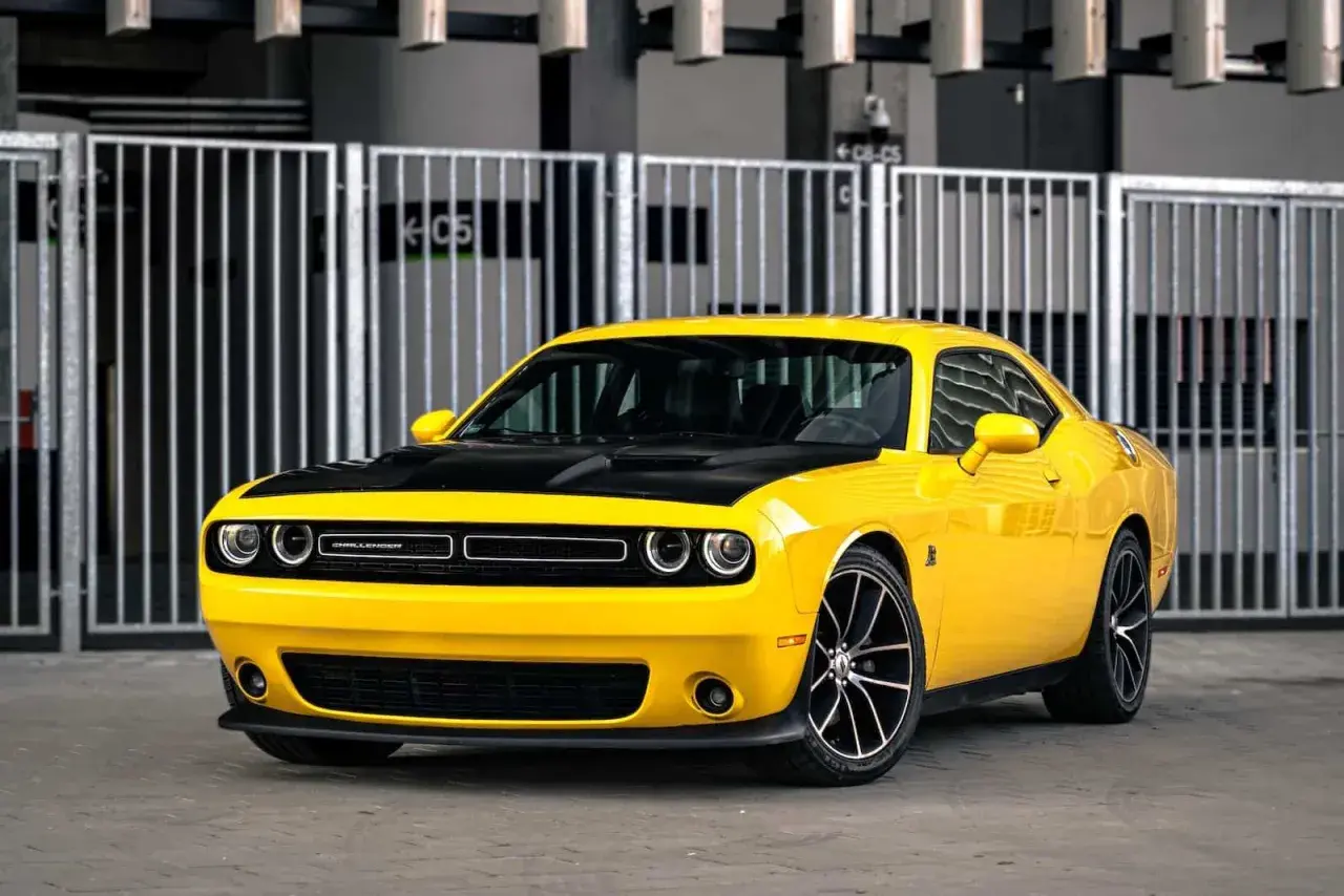 Żółty Dodge Challenger z czarną maską, idealny na letnie przejażdżki. Sprawdź jego atrakcyjną dodge challenger cena!