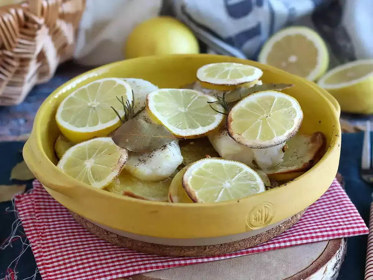 Dos de cabillaud au four, garni de rondelles de citron, de romarin et de feuilles de laurier. Un plat savoureux et parfumé.
