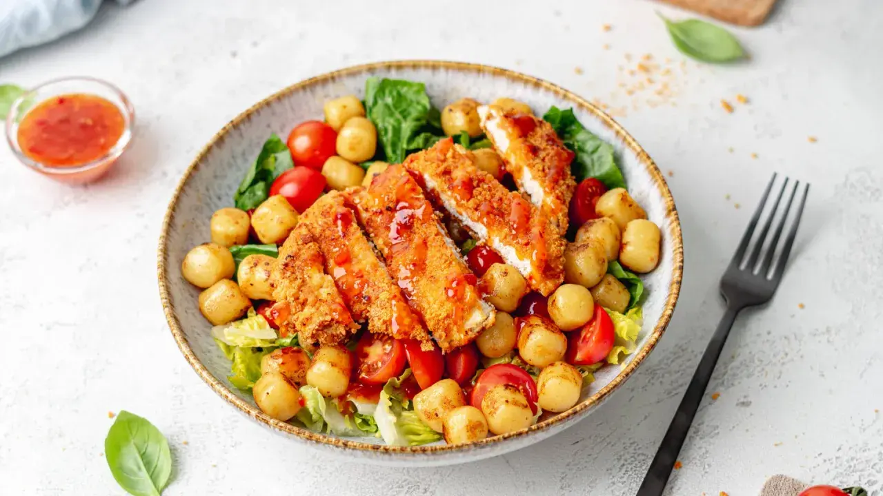 Herzhafter warmer Gnocchi Salat mit knusprigem Hähnchen, Kirschtomaten und süß-saurer Sauce. Ein Genuss!