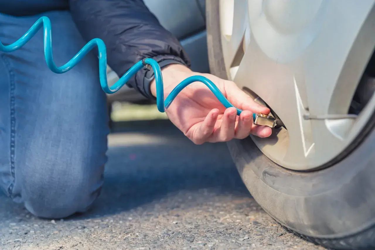 Persona infla ruedas con nitrógeno usando una manguera azul.