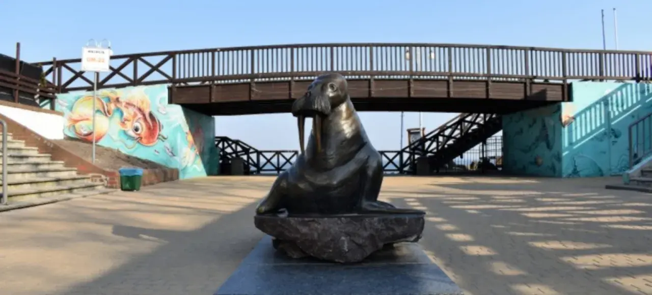 Mielno pomnik morsa przy malowniczej kładce z muralami.