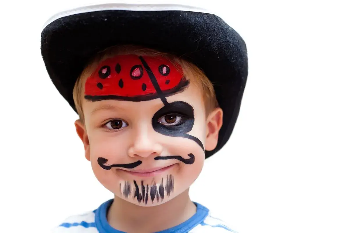 Ein Junge mit Piratenhut und gemaltem Bart und Augenklappe. Kinder lieben es, sich zu verkleiden und zu schminken.