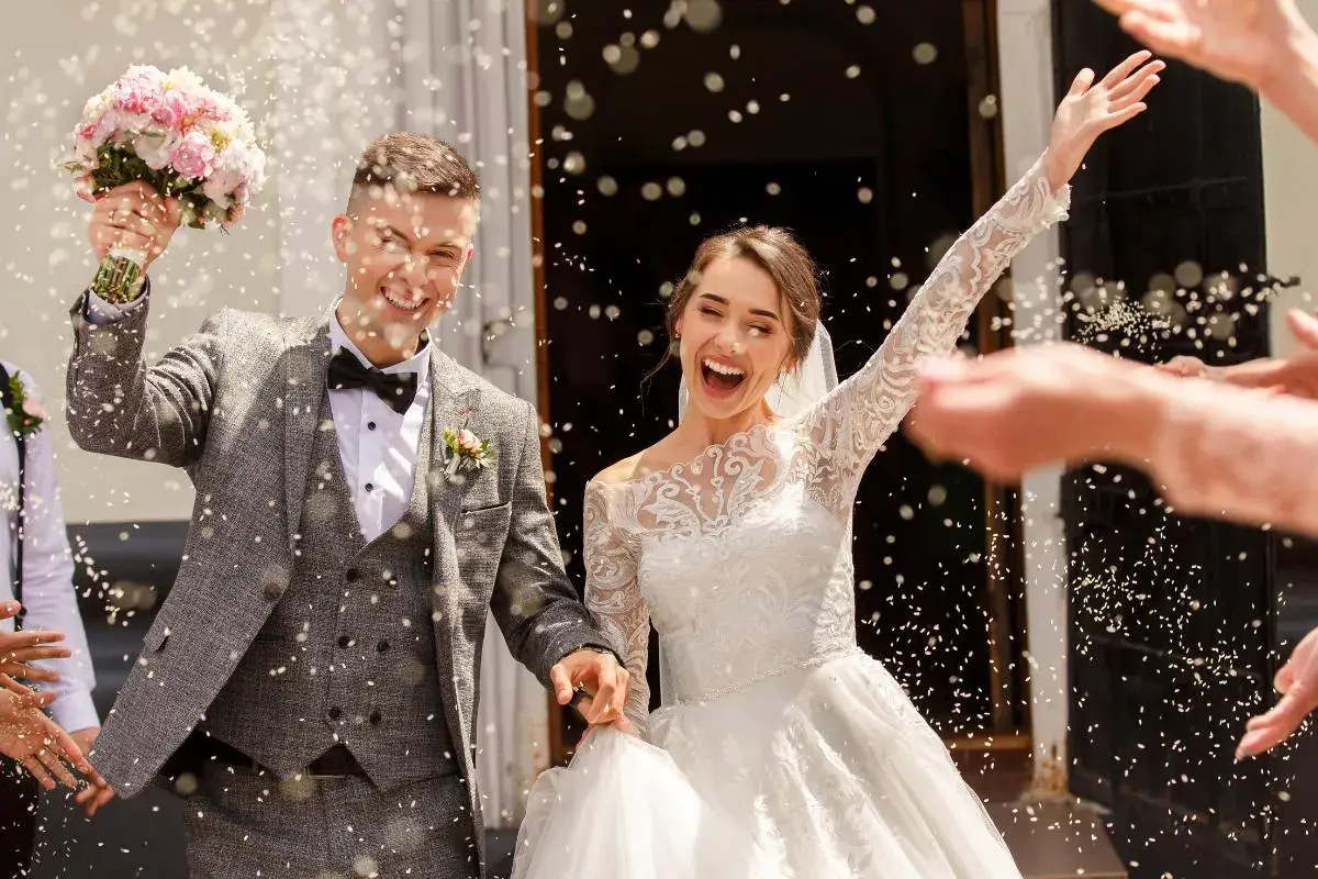 Novios felices, rodeados de confeti, celebrando su boda. ¡Un sueño hecho realidad!