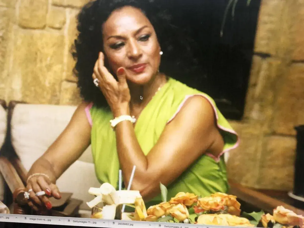 Lola Flores, icónica artista, sonríe con un cigarrillo en la mano. Su fecha de nacimiento es un misterio para muchos, pero su legado es eterno.