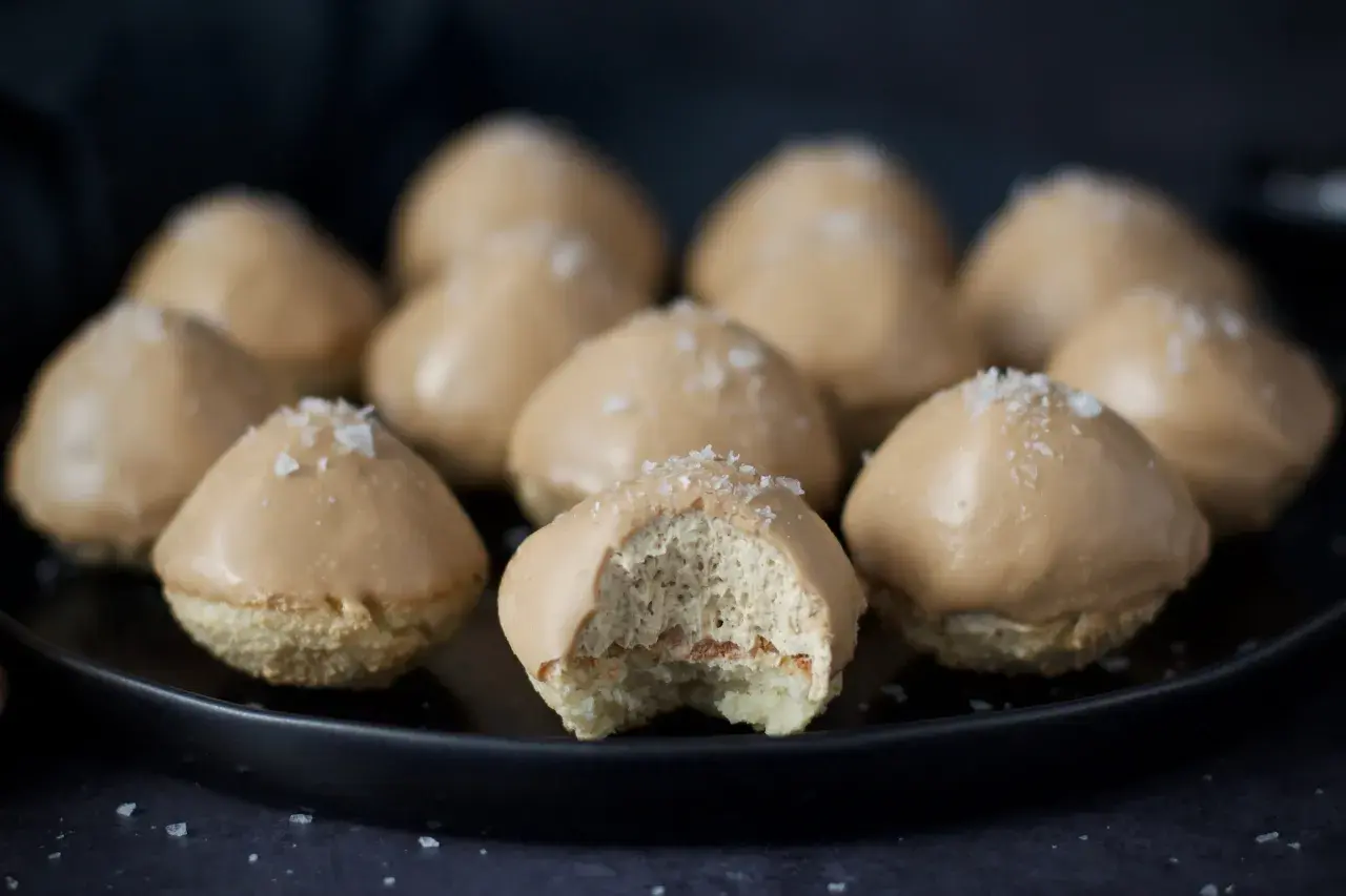 Små, karamellglaserade biskvier med flingsalt, ett läckert biskvier recept. En är uppäten och visar det fluffiga inkråmet.