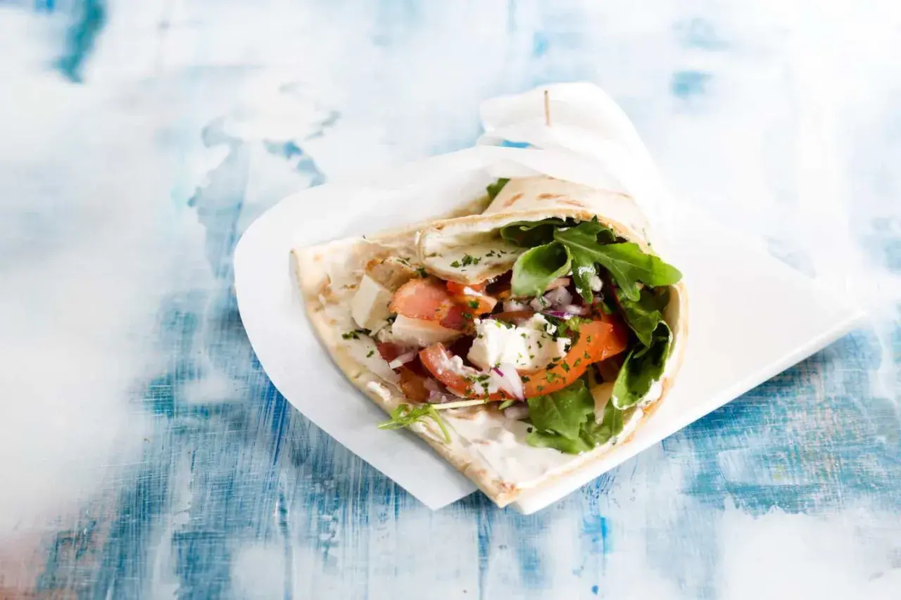 En gyros med fetaost, tomat, lök och ruccola. Vissa religioner anser att fläsk är haram, vilket betyder förbjudet.