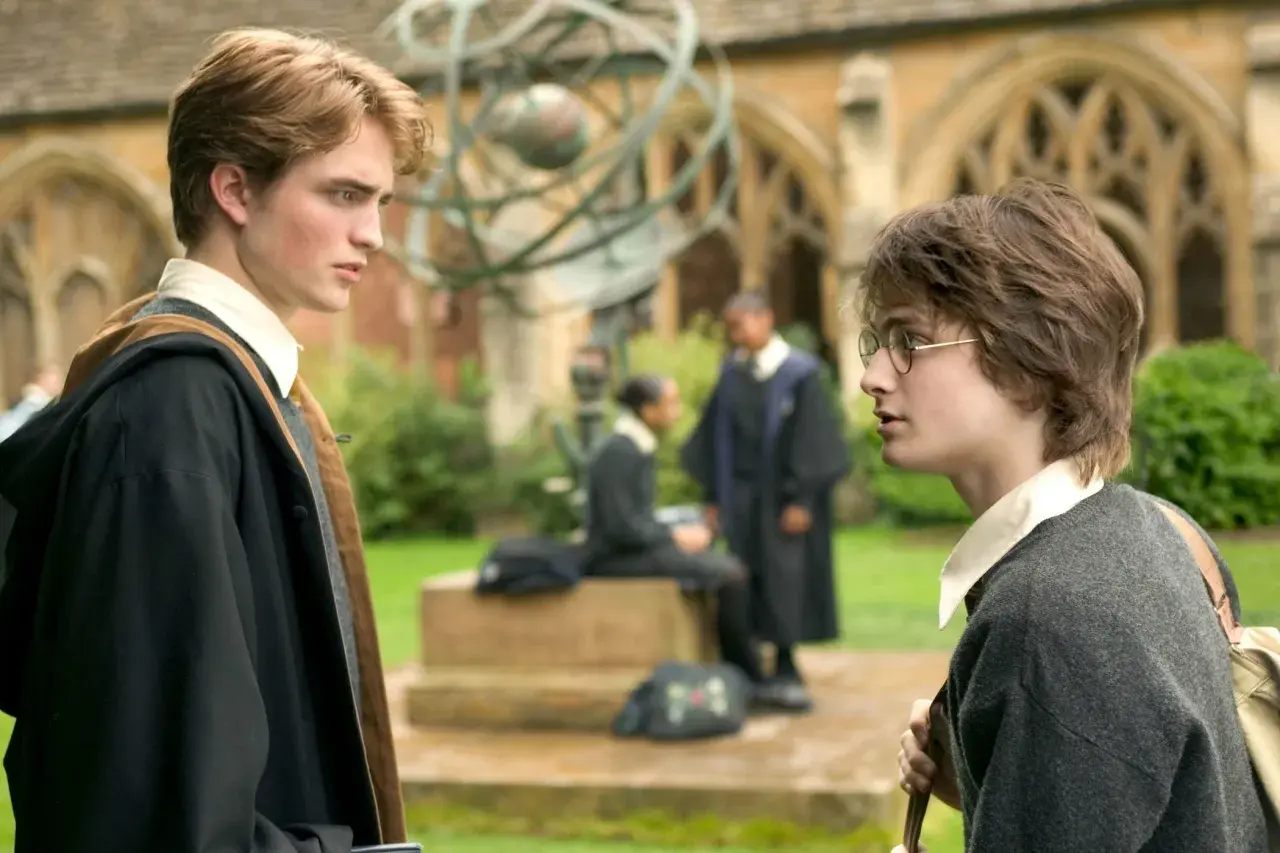 Robert Pattinson jako Cedric Diggory rozmawia z Harrym Potterem na dziedzińcu Hogwartu.