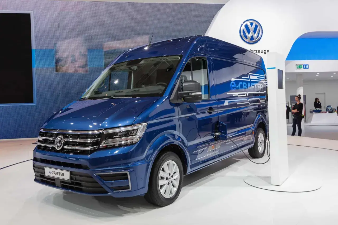 Niebieski elektryczny kamper e-Crafter podłączony do ładowarki.