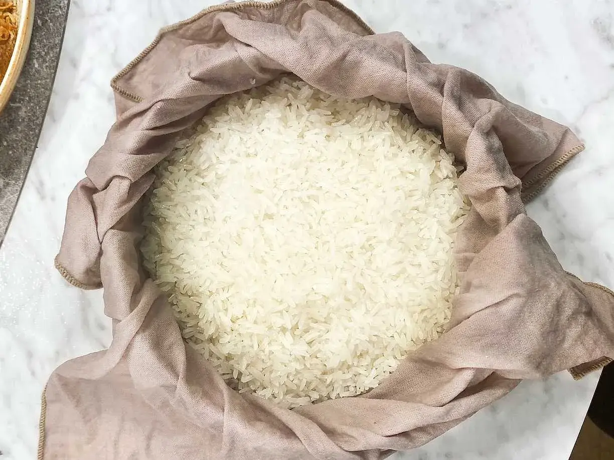 En hög med fluffigt, klibbigt ris inlindat i en ljusrosa tygduk.