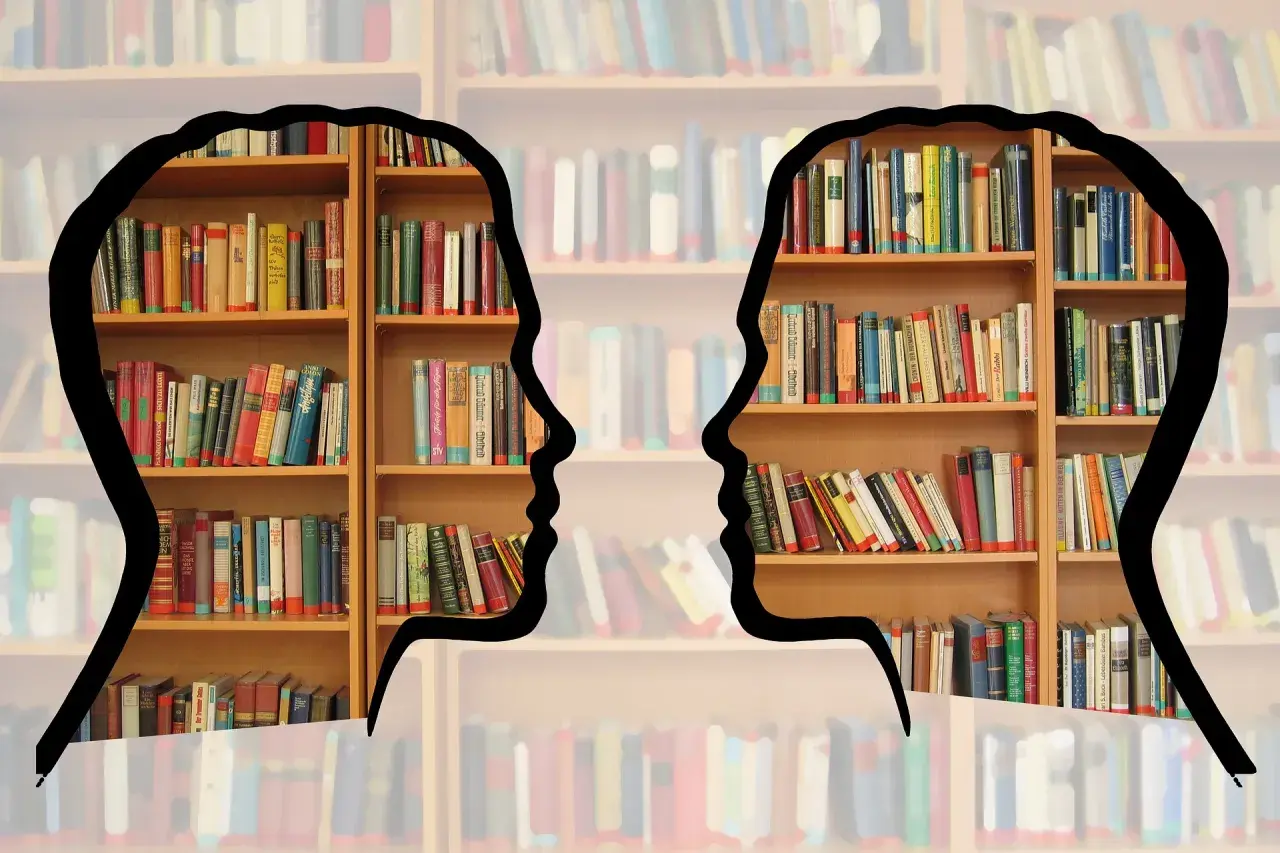 Dwie sylwetki ludzkie zarysowane na tle regałów z książkami. Idealne dla osób zainteresowanych bibliotekoznawstwo studia.