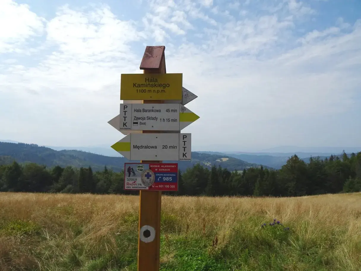 Rozdroże szlaków turystycznych. Tabliczka informuje o wysokości 1100 m n.p.m. i kierunkach do Hali Barankowej, Zawoi Składów i Mędralowej. To punkt startowy na szlak na Halę Kamińskiego.