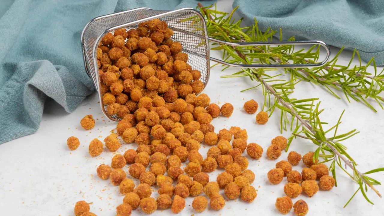 Ceci croccanti in friggitrice ad aria, appena usciti dal cestello, con rametti di rosmarino.