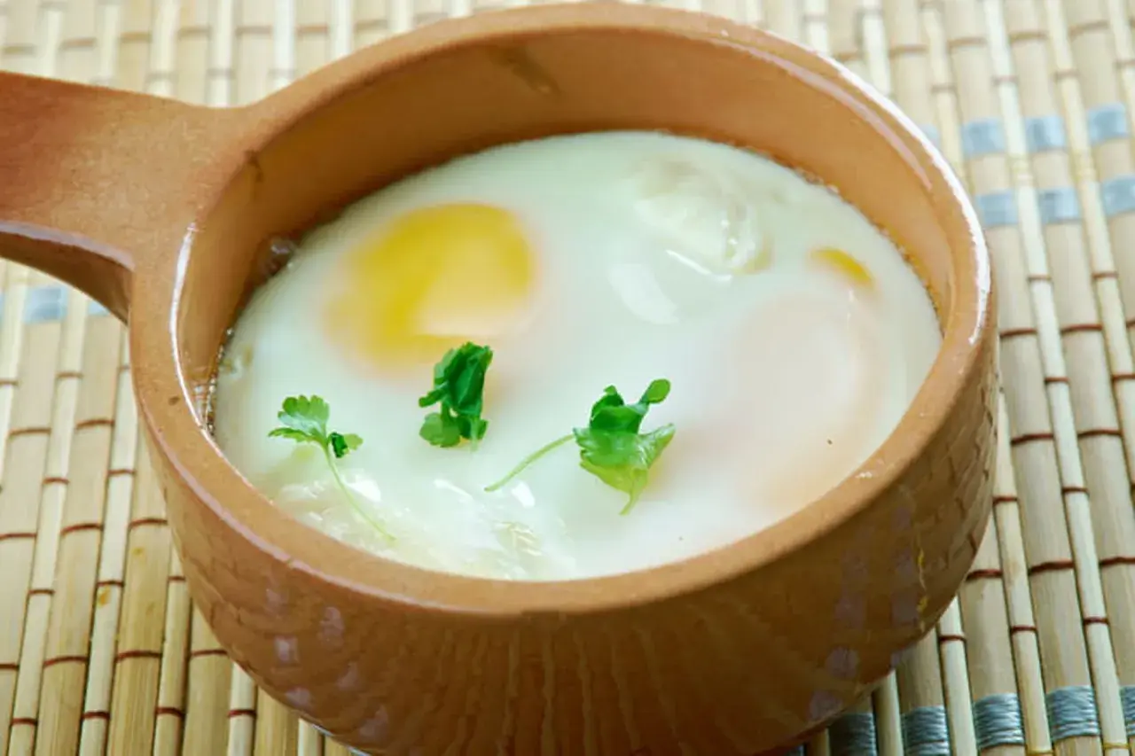Un œuf cocotte crémeux, cuit au four, garni de persil frais. Un délice simple et réconfortant.