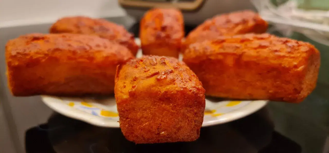 Petits pains dorés, peut-être un cake chorizo, sur une assiette.