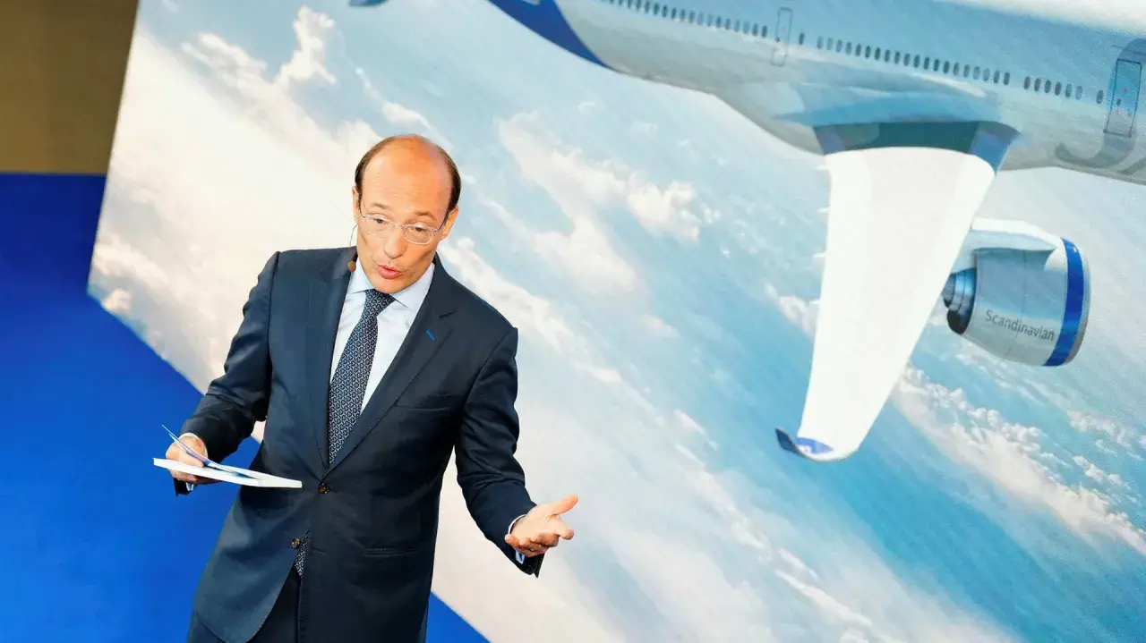 SAS chef presenterar flygplansdetaljer framför en storbildsskärm med ett flygplan.