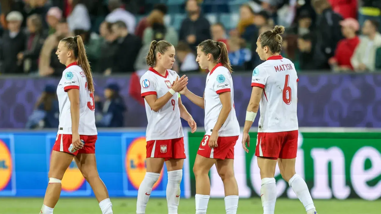 Piłkarki w biało-czerwonych strojach, reprezentujące polskie dania, na boisku.
