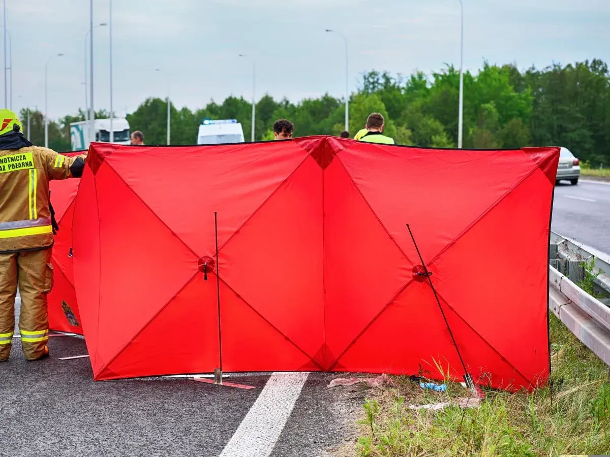 Czerwony parawan przy wypadku oznacza miejsce zdarzenia, gdzie pracują służby ratunkowe.