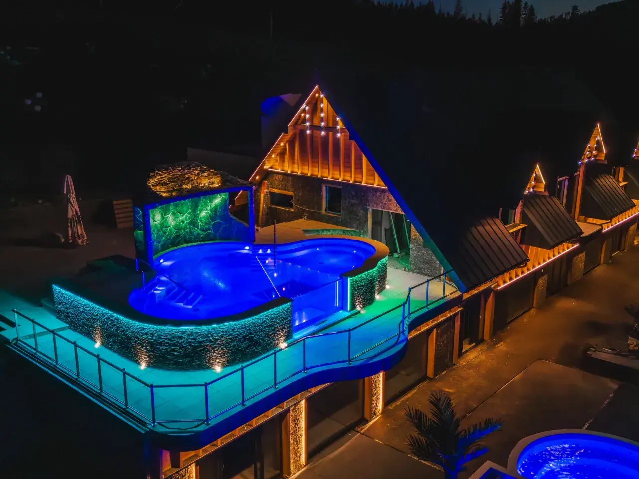 Nocny aquapark Stegna z podświetlanym basenem i architekturą góralską.