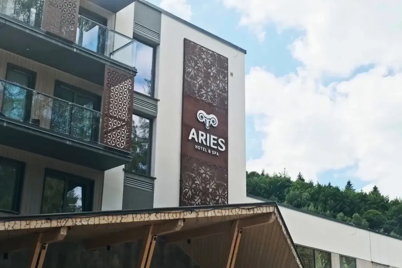 Nowoczesny hotel Aries w Szczyrku z ozdobnymi panelami i widokiem na las.
