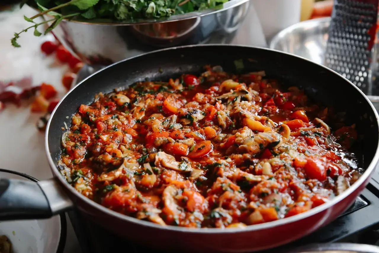 Poêlée de légumes colorée, prête pour une recette ratatouille traditionnelle. Tomates, courgettes et aubergines mijotent.