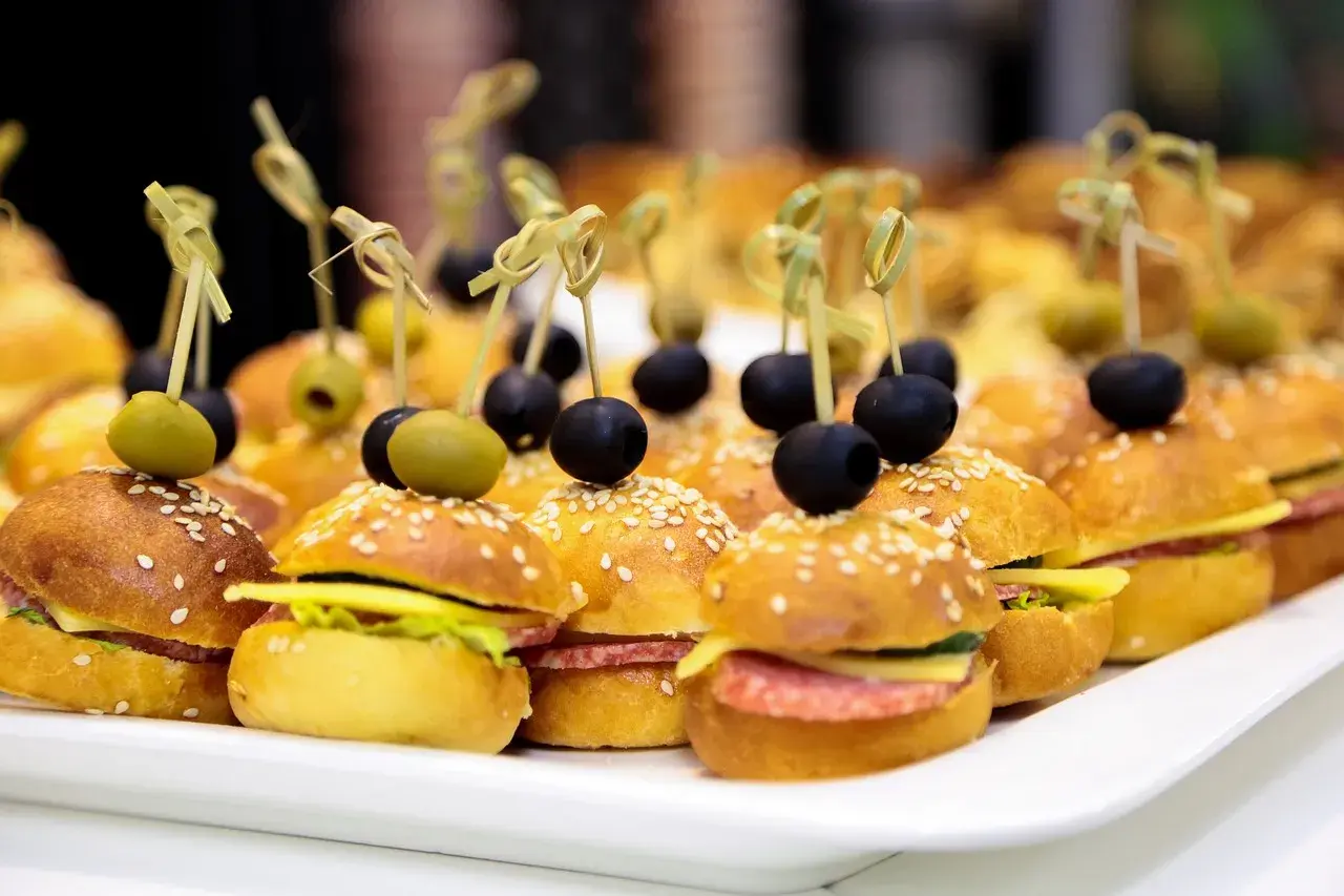 Mini kanapki na przyjęcie, idealne na catering w Warszawie. Mini burgery z oliwkami i sezamem.