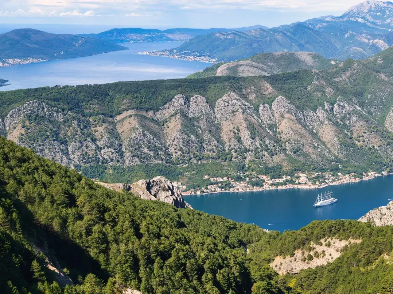 Atemberaubender Blick auf die Bucht von Kotor. Meine Urlaub in Montenegro Erfahrungen sind unvergesslich. Ein Segelschiff gleitet auf dem tiefblauen Wasser.