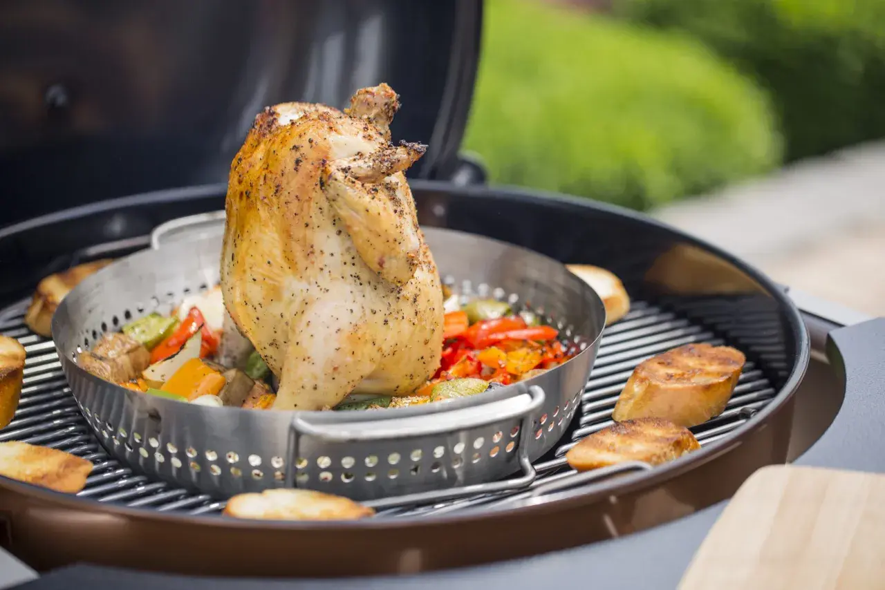 Un poulet rôti sur un barbecue, avec des légumes colorés et des tranches de pain grillé. Le poulet est assaisonné et semble juteux, prêt à être dégusté.